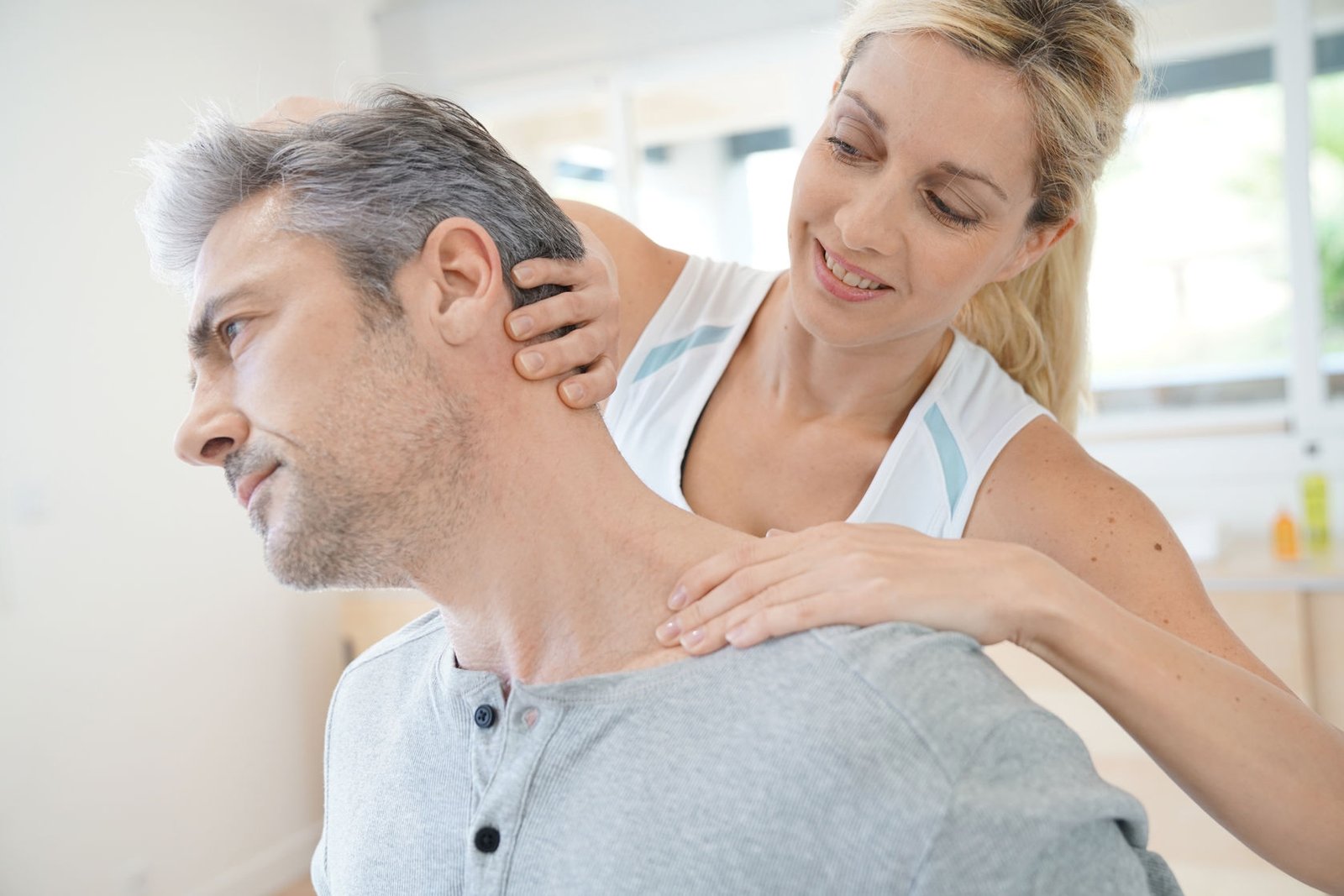 Physiotherapist massaging patient with neck pain